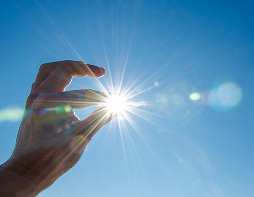 Picture of sun through fingers | 5 Secrets to Extending the Life of Your Hearing Aids 