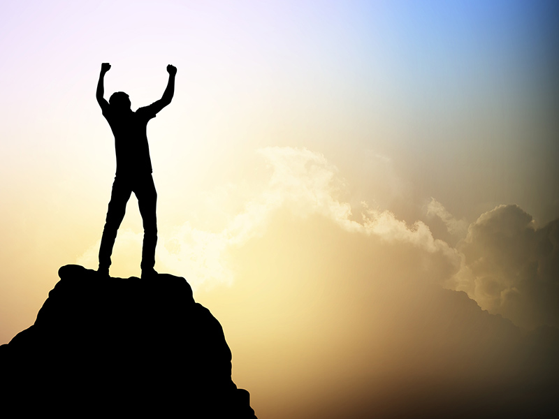 Picture of person on mountain with hands in the air