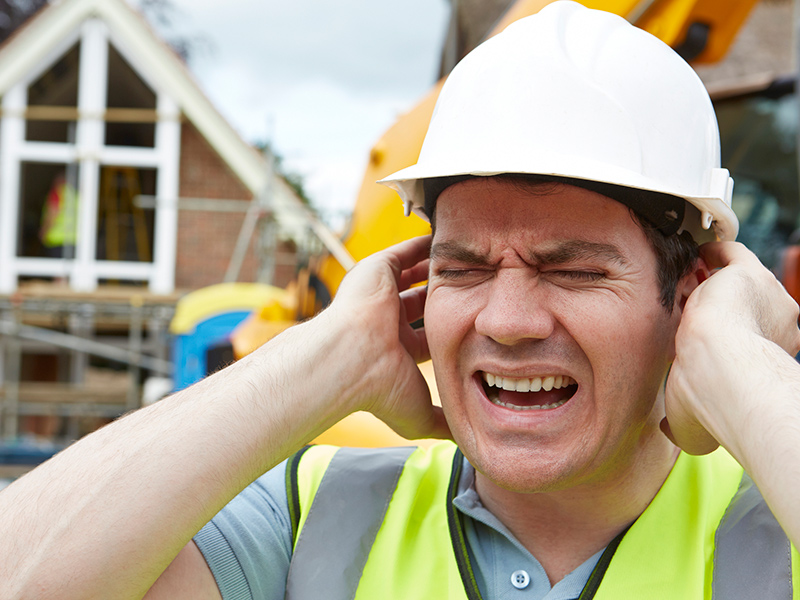 Picture of construction worker with hands over ears