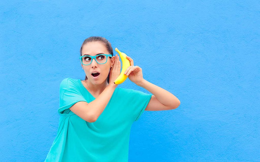 Woman with a banana up to her ear