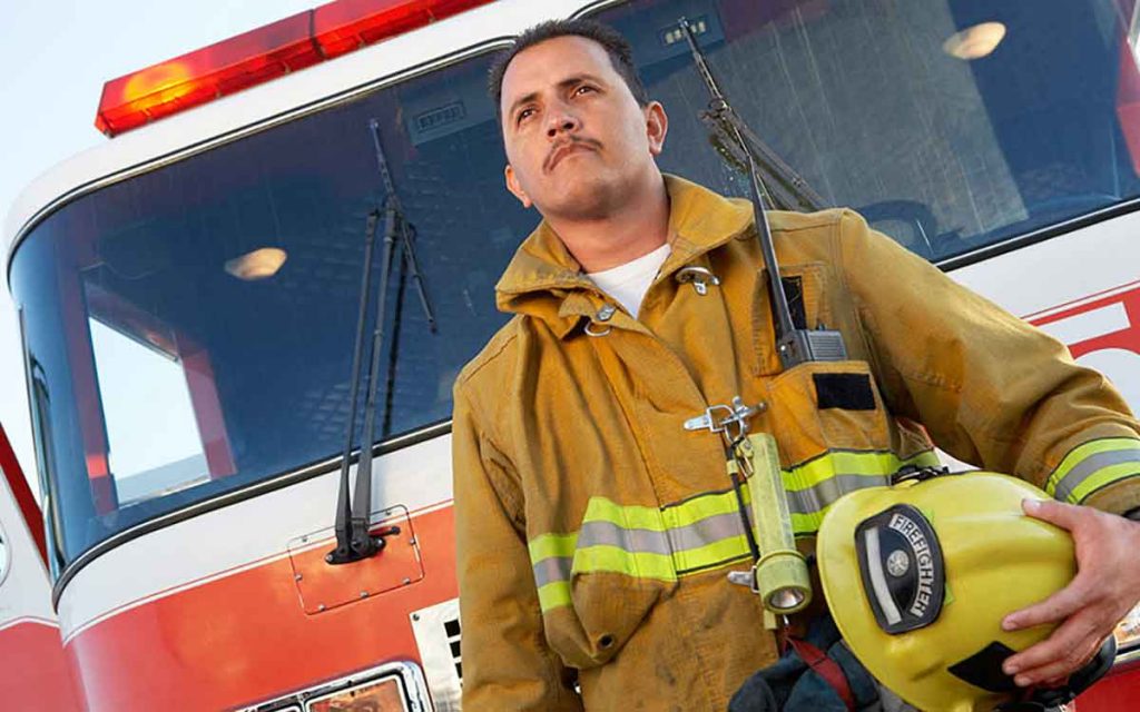 Firefighter in front of a firetruck.