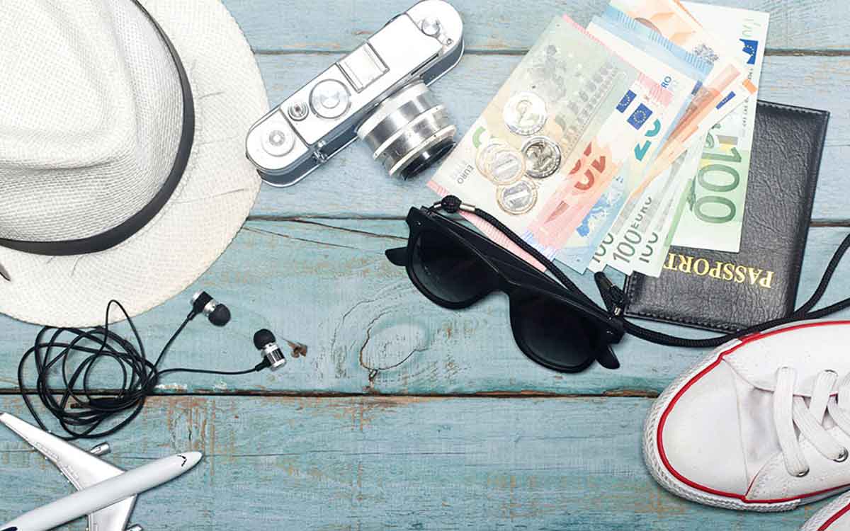 Picture of hat, glasses and money showing traveling items.