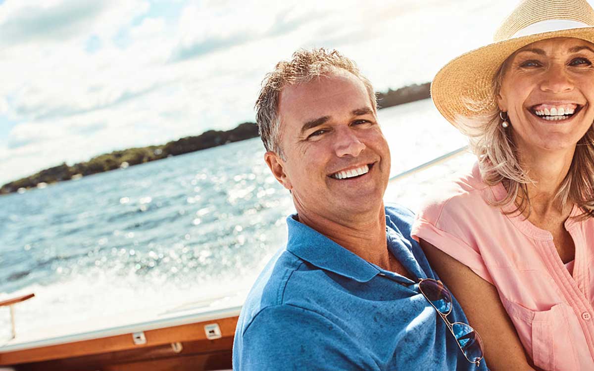 Happy couple on boat discovering the benefits of hearing aids.
