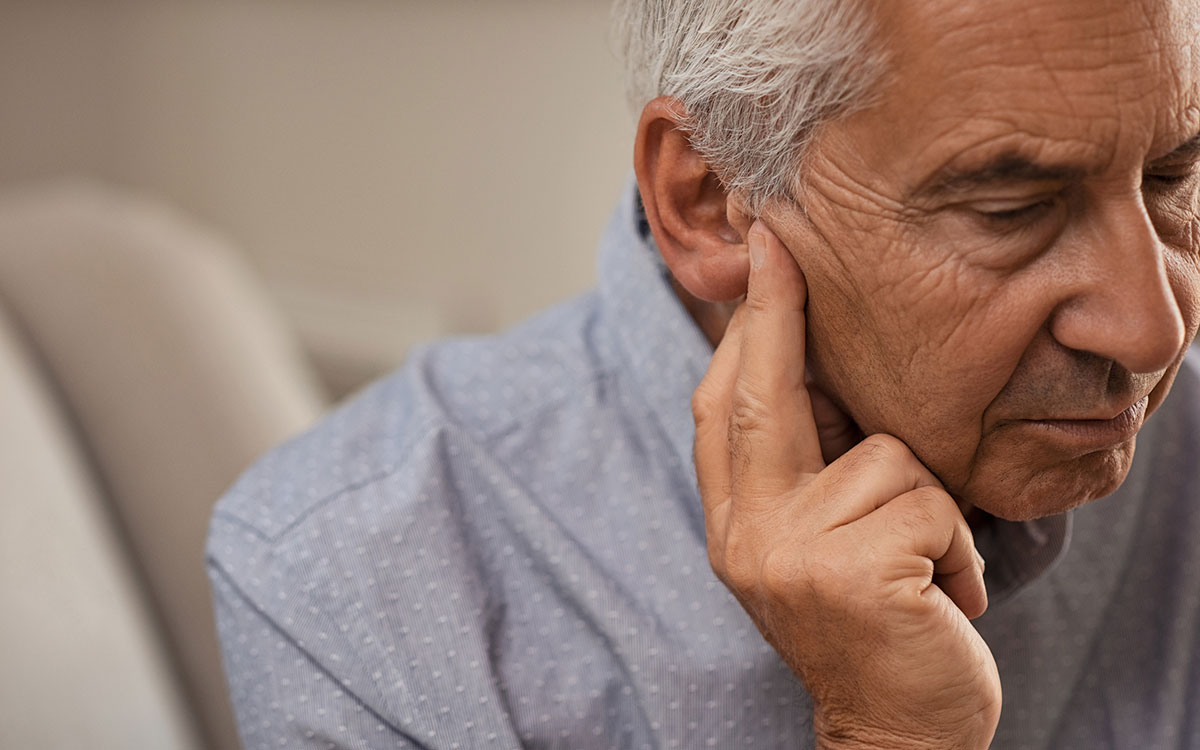 Man making hearing loss worse by pushing ear wax in.