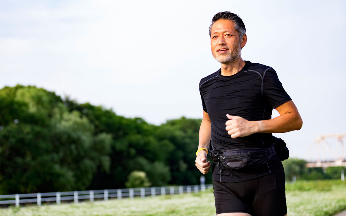 Man running with a fitness tracking hearing aid.