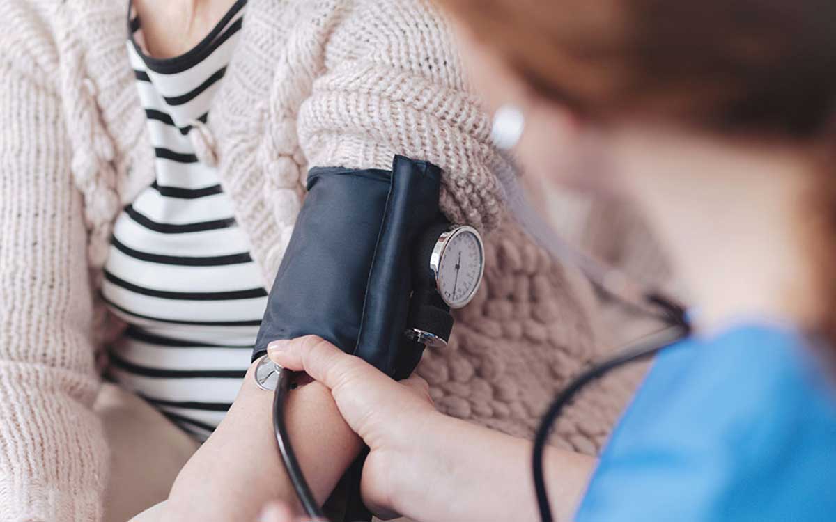 Woman getting blood pressure checked. Health problems and hearing loss.
