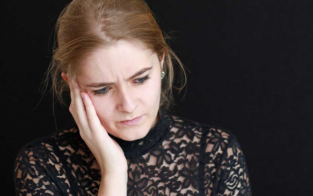 Woman experiencing tinnitus pain needing tinnitus therapy.