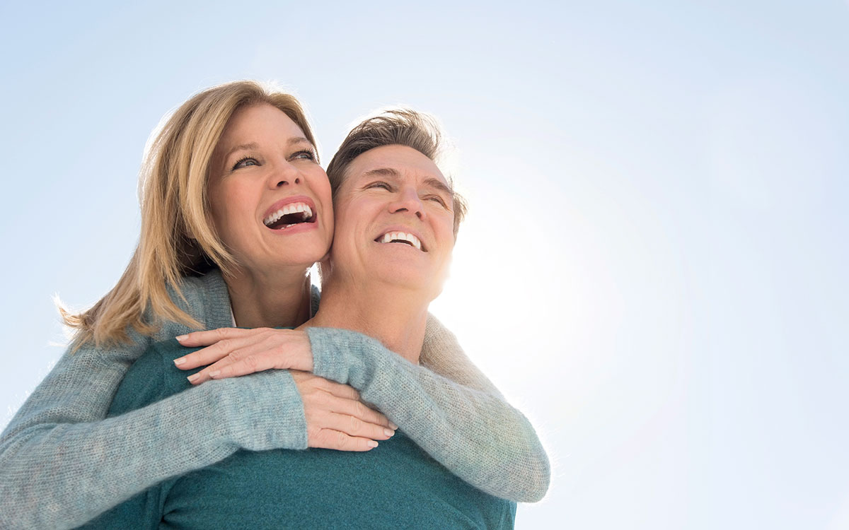 Happy middle aged couple enjoying the benefits of hearing aids.