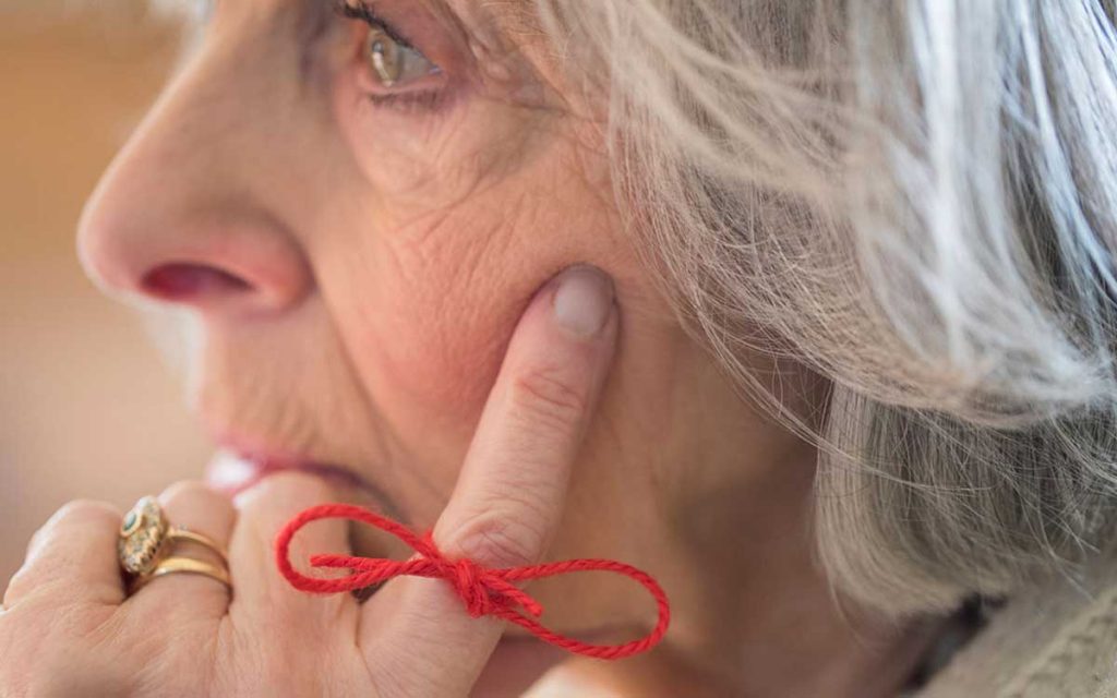 Woman with a string tied around her finger because she can't remember or is it hearing losss?