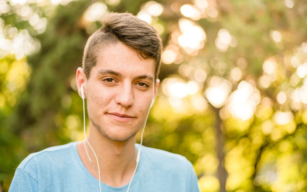 Teen listening to music on earbuds too loudly.