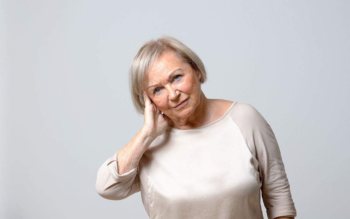 Woman suffering from Tinnitus who is considering hearing aids.
