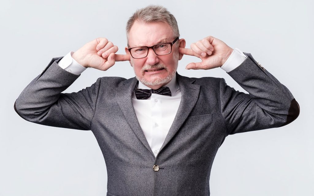 Man with his fingers in his ears because they are clogged.