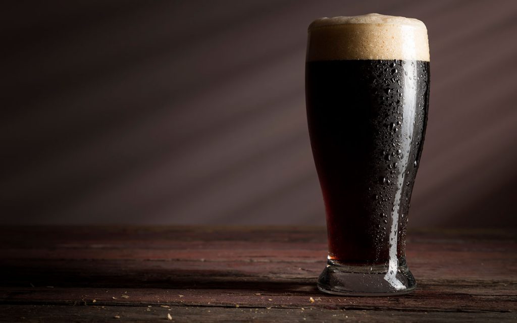 Glass of dark beer which may help with hearing loss.