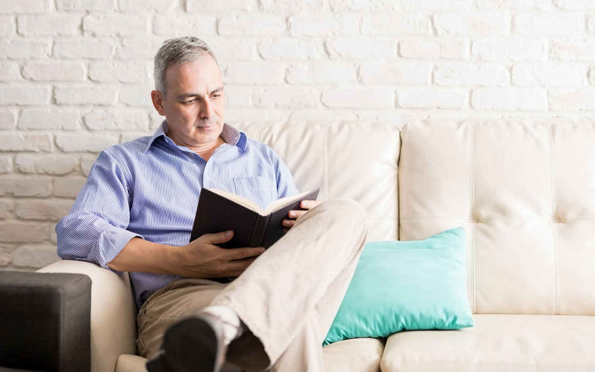 Alt image: Man learning how to use his hearing aids by reading aloud.