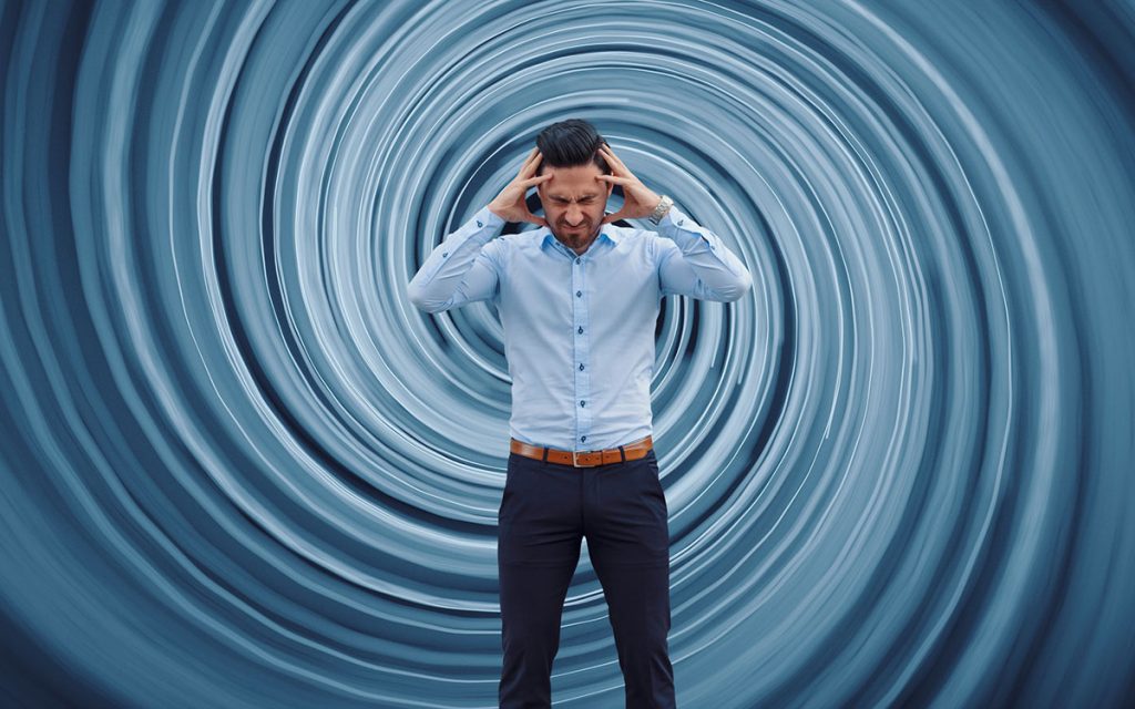 Man with dizzy swirl behind him suffering from hearing loss.