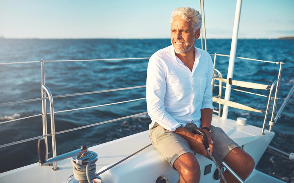 Happy middle aged man with hearing aid accessories.