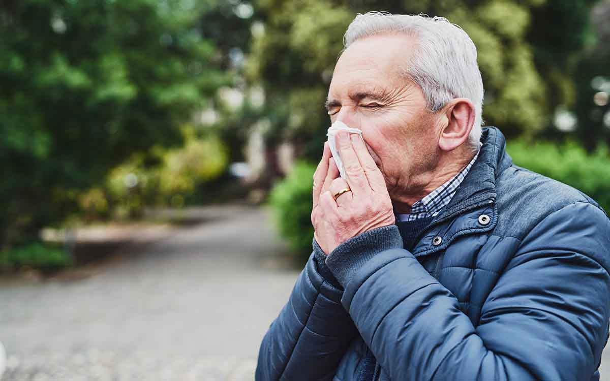 Man blowing his nose because of sinus infection.