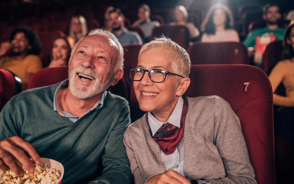 Senior couple with hearing loss in the movie theater.