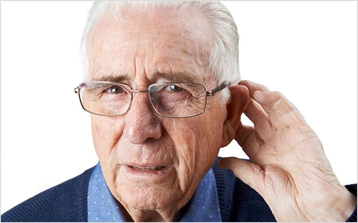 Man with his hand up to his ear wondering what Tinnitus sounds like.