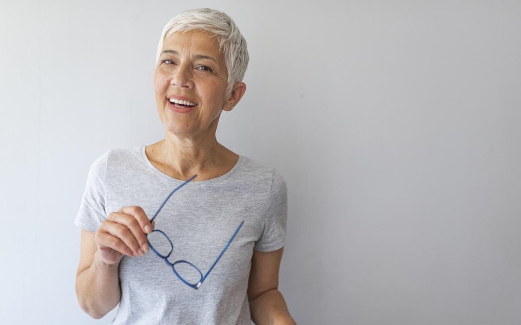 Happy mid woman pondering hearing aids or psaps.