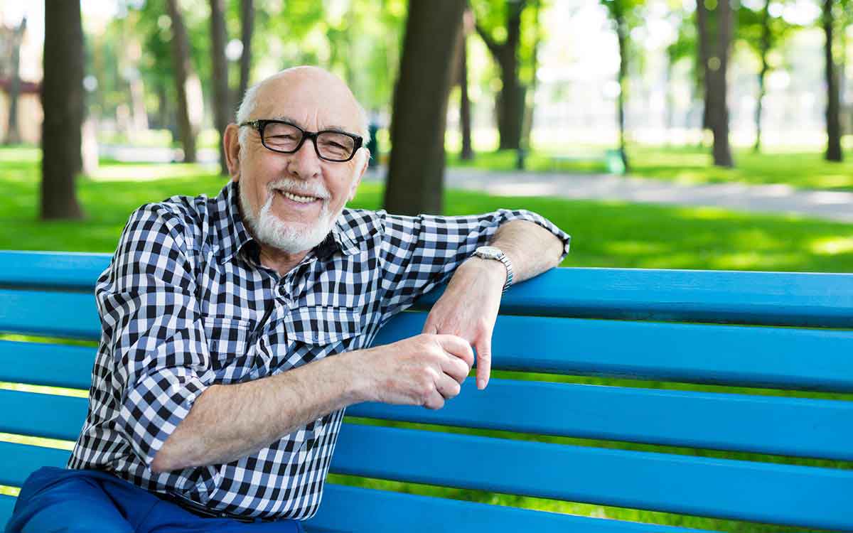 Relaxed senior man outdoors with options about hearing loss.