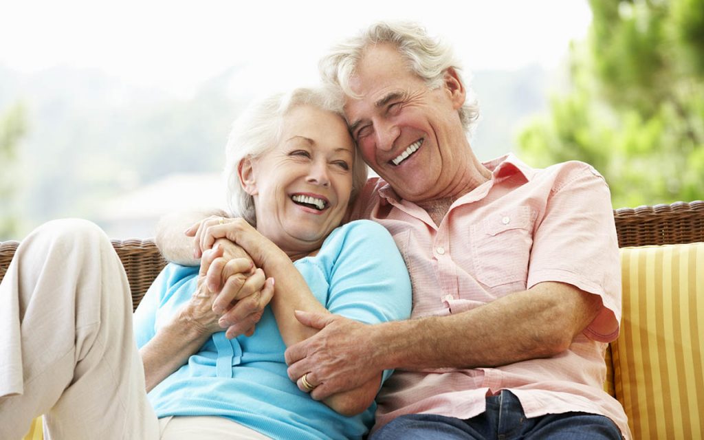 Happy senior couple avoiding the negative stigma by wearing hearing aids.