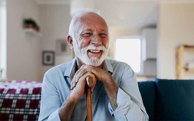 Happy senior man who has upgraded his hearing aid.