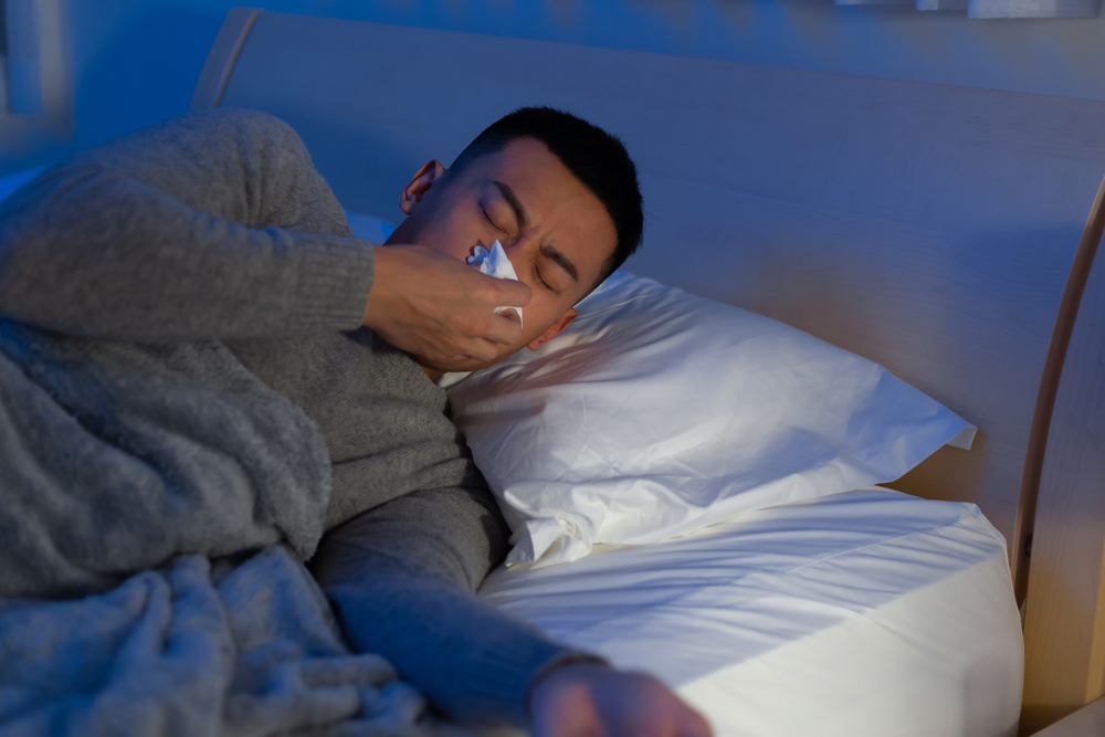 man with sinus infection symptoms at night.