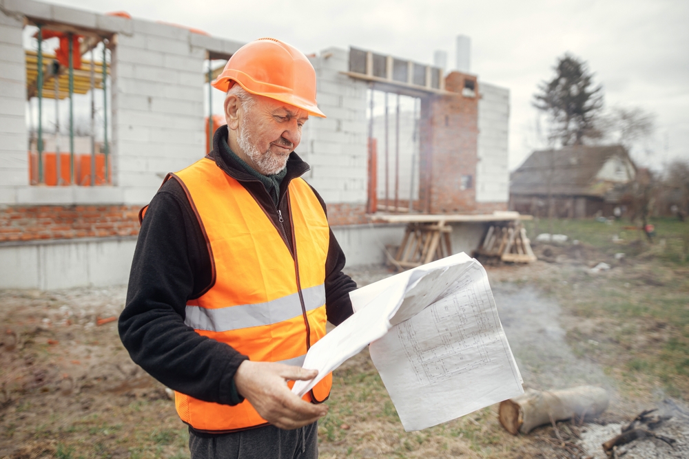 contractor checking plans at construction site.
