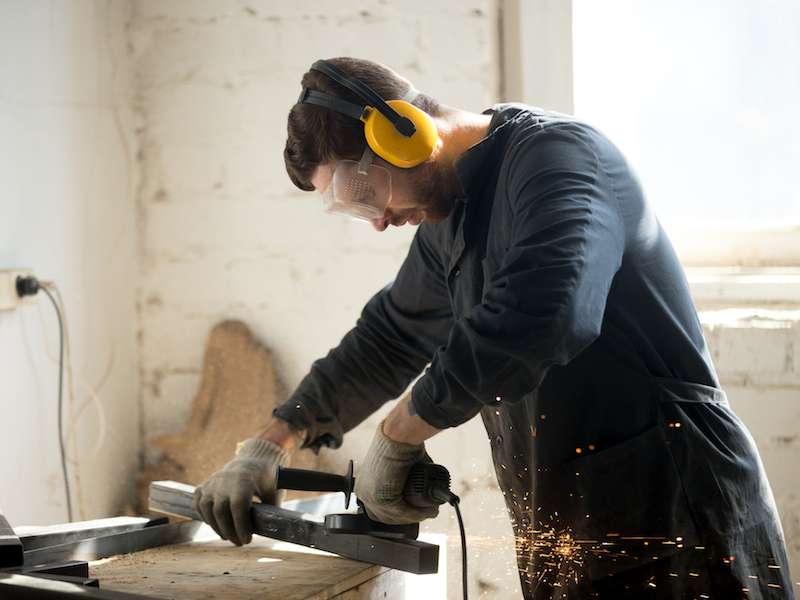 Man wearing hearing protection in his workshop to protect his hearing.