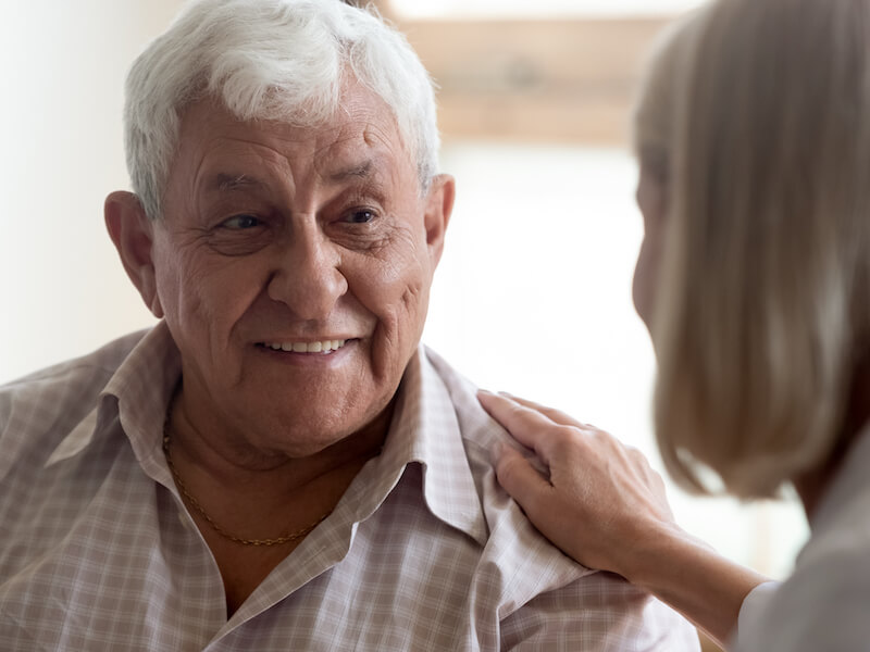 Man happily talking with his hearing specialist about restoring his hearing.