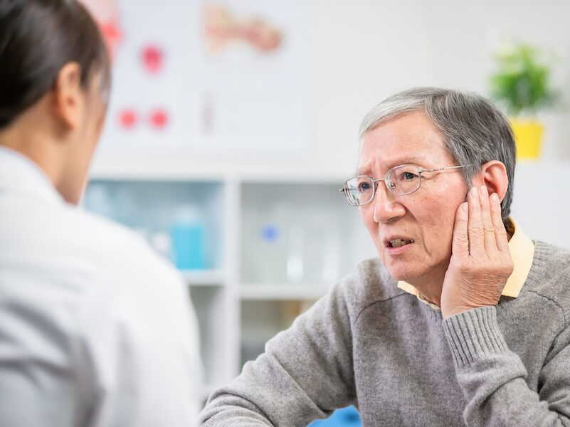 Woman’s hearing aids no longer working well and she is straining to hear.
