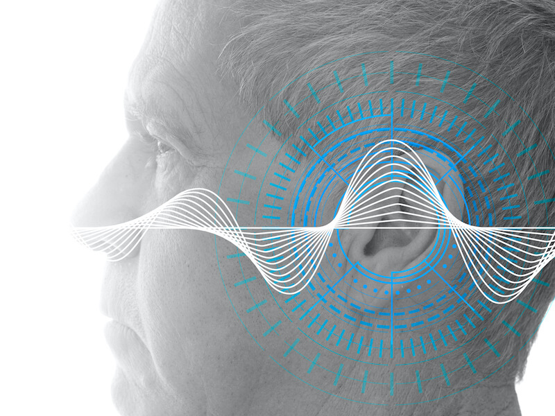 Hearing test showing ear of senior man with sound waves simulation technology