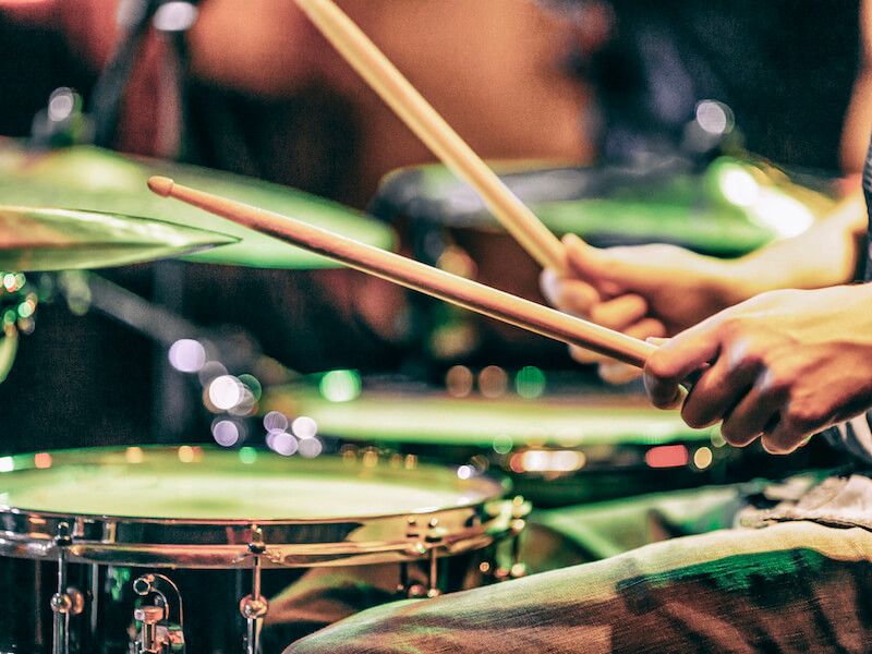 Close up of drummer's hands playing a drum kit. Drums are very loud, the player should be wearing hearing protection.