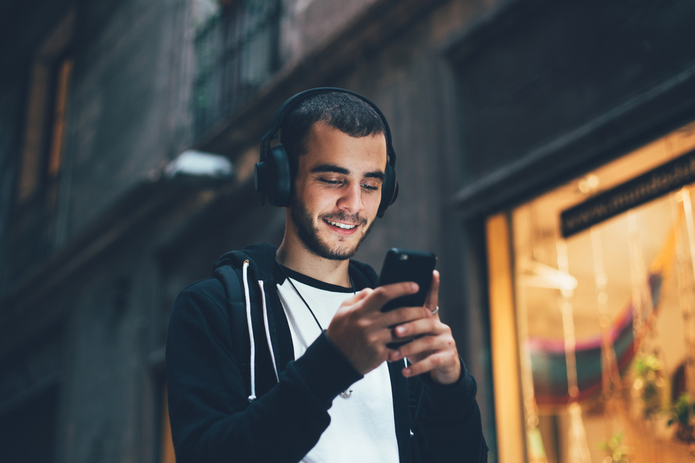 man outside listening to music with headphones.