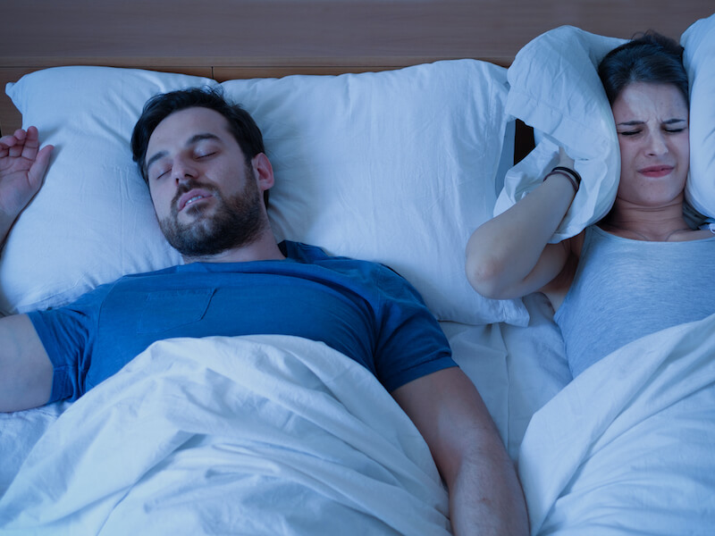 Man snoring keeping his partner awake because he has sleep apnea