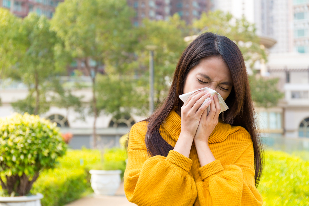 woman suffering from spring allergies outside.