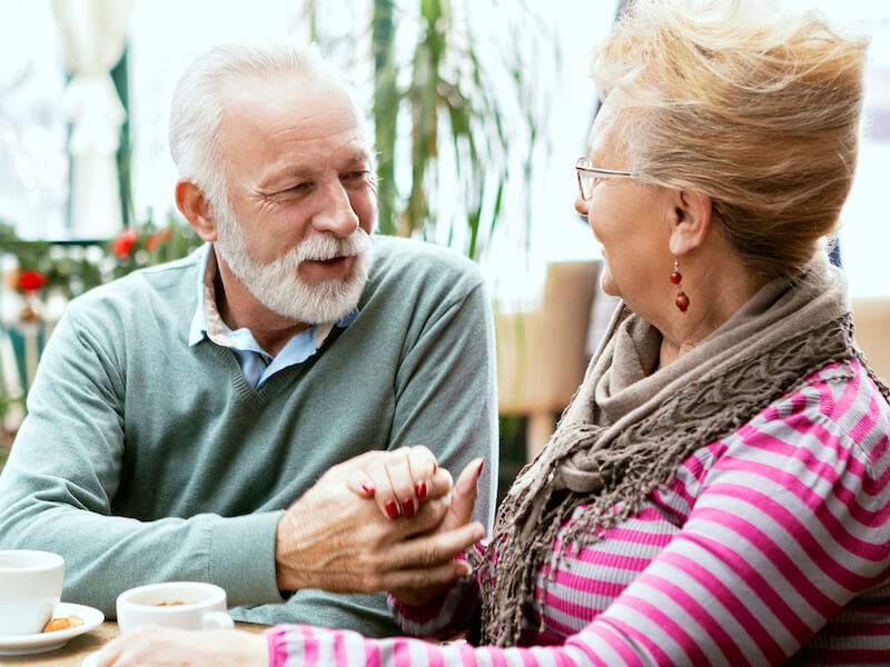 Senior couple with hearing loss drinking morning coffee together