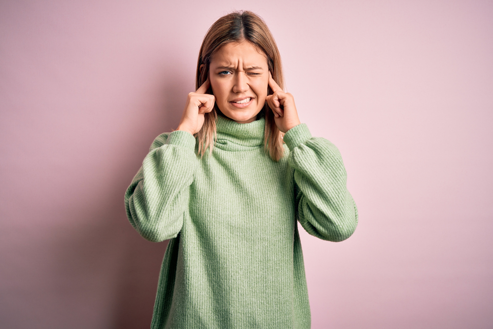 A woman touching her ears due to irritation and dryness