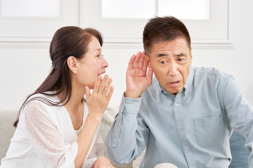 A woman speaking with a man who has hearing loss