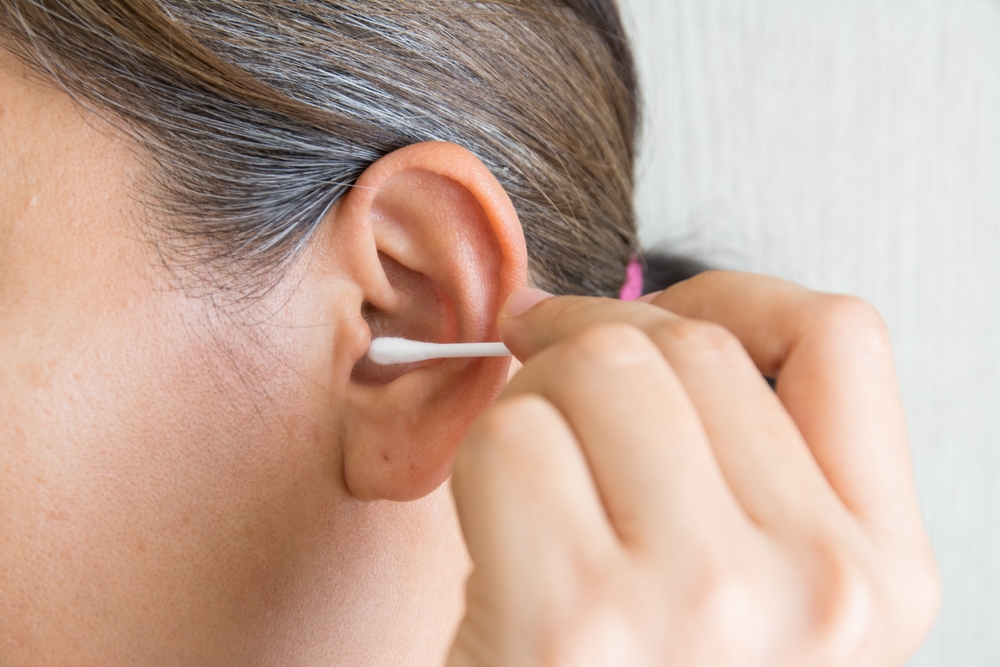 Lady putting a cotton swab in her ear