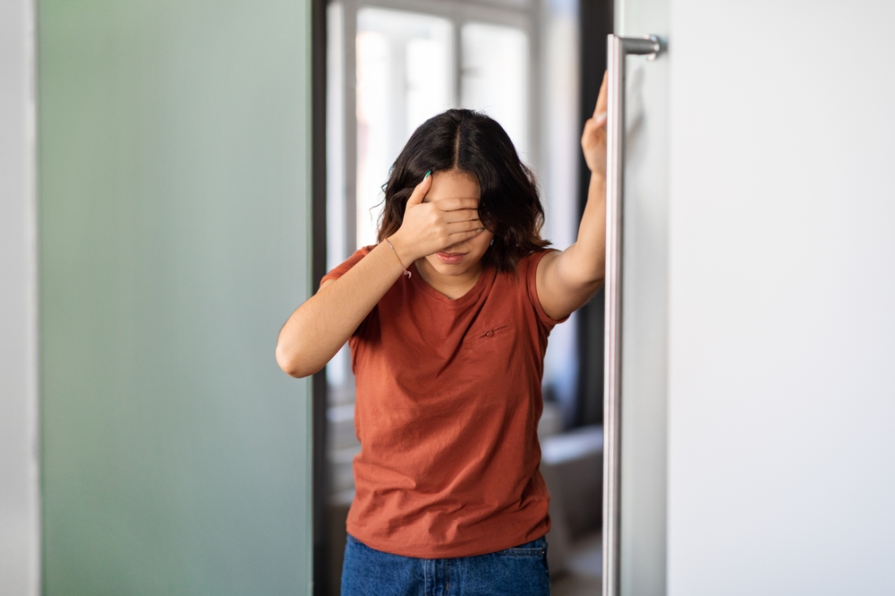 Lady leaning on a wall because she is dizzy